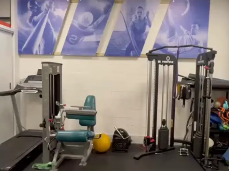 Rehab gym with a cable machine, a leg extension machine and a treadmill at All In One Specialty Health in Miami Gardens